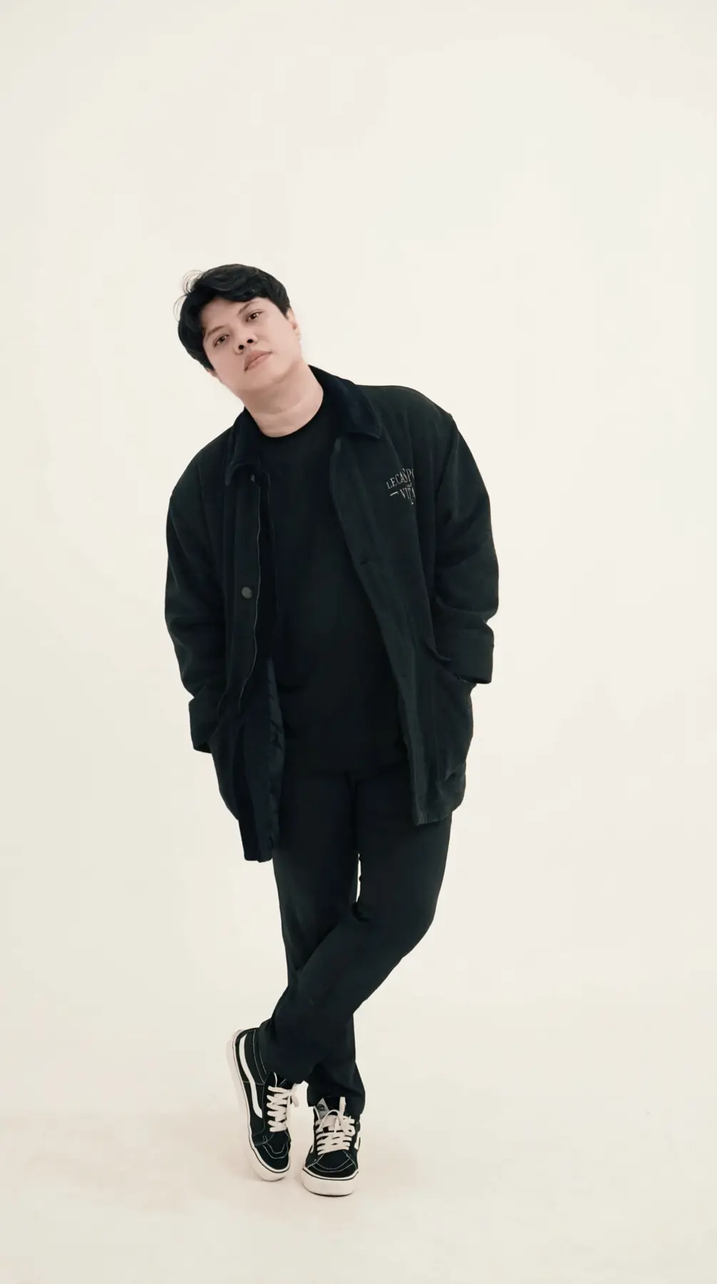 Portrait of Welige Eko Raharjo in black against a white wall
